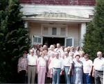About 30 men and women pose for a group photo in front of Annelly School during a reunion