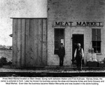 Two Men Standing in Front of Ames Meat Market