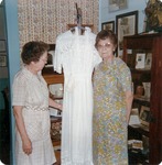 Two Women Next to a Wedding Gown