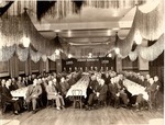 A banquet hall with men and women sitting at tables