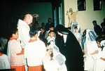 Father Oliver K. and a Nun with Hispanic Children