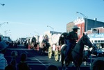Four Horse-Drawn Covered Wagons in a Parade