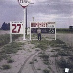 Man Standing by the Humphrey Oil Sign