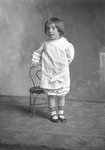 Box 15, Neg. No. 9781-5: Child Standing Next to a Chair