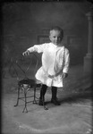 Box 16, Neg. No. 14042: Boy Standing by a Chair