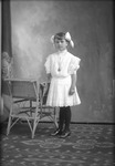 Box 21, Neg. No. 29085: Girl Standing Next to a Chair