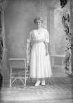 Box 21, Neg. No. 30021: Woman Standing by a Chair