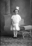 Box 21, Neg. No. 30107: Girl Standing Next to a Chair