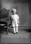 Box 24, Neg. No. 49452: Boy Standing in Front of a Chair