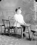 Box 35, Neg. No. 36009: Girl Sitting with a Row of Chairs
