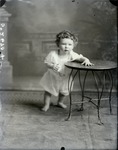 Box 42, Neg. No. 5267: Child Standing Next to a Table