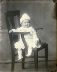 Box 43, Neg. No. 53028: Baby Sitting Sideways on a Chair