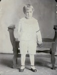 Box 44, Neg. No. 52601: Boy Standing in front of a Bench