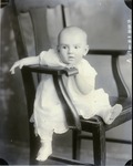 Box 46, Neg. No. 54414-RA: Baby Sitting Sideways on a Chair