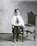 Box 47, Neg. No. 49523: Boy Standing Next to a Chair