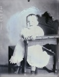 Box 47, Neg. No. 49707: Baby Sitting Sideways on a Chair