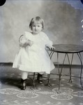 Box 51, Neg. No. 40487: Girl Standing by a Table