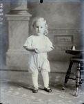 Box 52, Neg. No. 40311: Girl Standing Next to a Stool and Bell
