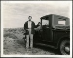 055_03: A Man Standing Next to a Truck by George Fryer Sternberg 1883-1969