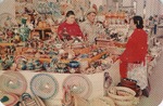 Postcard: Two Women and One Man Standing Among Various Mexican Crafts