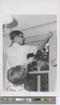 Male Student Installing Curtain Rods with Assistance in the Catholic Student Center in 1969.