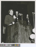 A Woman Speaking Behind a Wooden Lectern / Podium