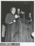 Anne Laughlin Speaking at a Wooden Lectern