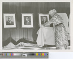 Woman Presenting Headshots of FHSU Presidents at the 75th Anniversary Exhibition