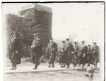 Group of Graduates Walking Down Sidewalk in Front of Tall Brick Tower in the 1920s